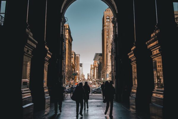 silhouette of people walking on a hallway leading to the streets